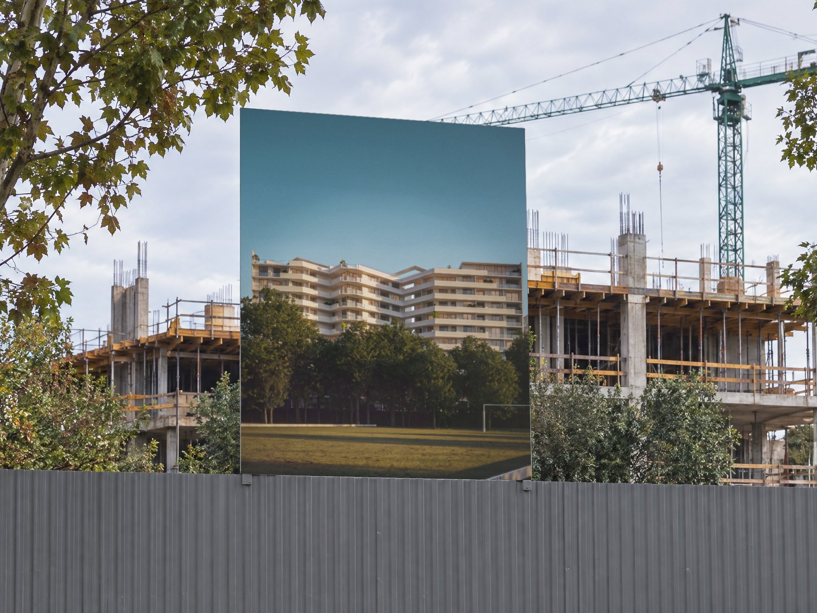 Render del edificio en el cartel de obra, sobre el vallado de la obra en construcción